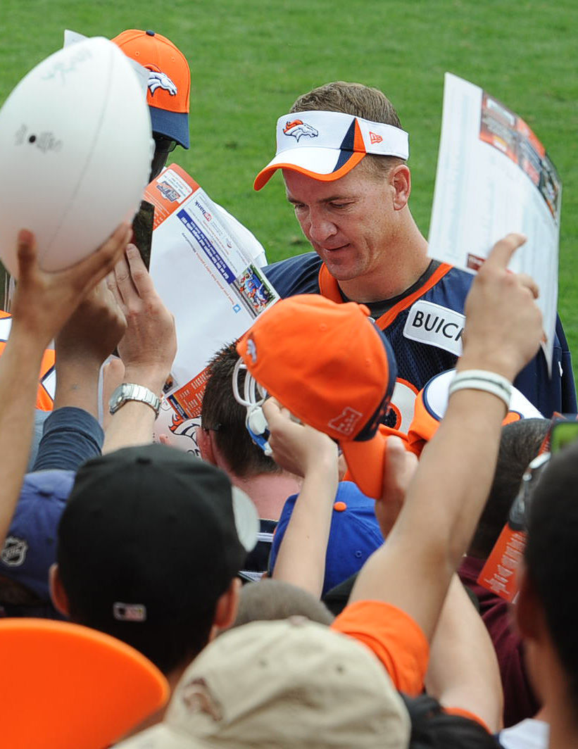 Denver quarterback Peyton Manning works feverishly to send as many fans home with his desired autograph as possible after Denver Broncos training camp. Manning was the most popular player for autograph seekers at Thursday's training camp.The Denver Broncos took to the field for the first day of training camp at Dove Valley on Thursday, July 25, 2013. (Jerilee Bennett/The Gazette)